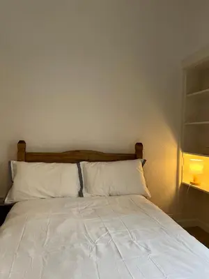 a bed with white sheets and pillows in a room at Spacious boutique two-bedroom apartment next to the castle in Edinburgh