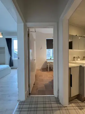 a view of a kitchen and a living room at Spacious boutique two-bedroom apartment next to the castle in Edinburgh