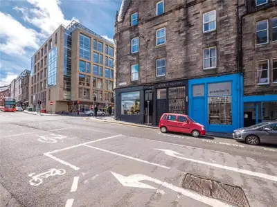 a red car parked on the side of a street at Spacious boutique two-bedroom apartment next to the castle in Edinburgh