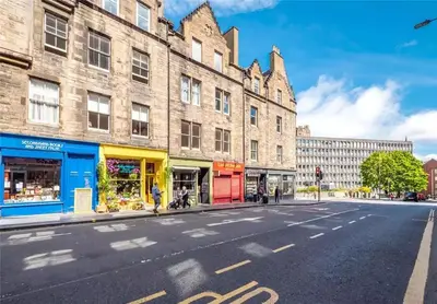 an empty street in front of a large brick building at Spacious boutique two-bedroom apartment next to the castle in Edinburgh