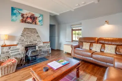 a living room with a couch and a fireplace at Courtyard Cottages Rose Cottage in Wigtown
