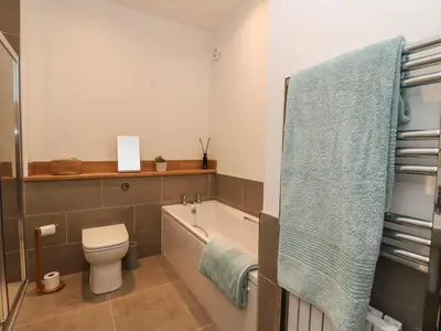 a bathroom with a bath tub and a toilet and a sink at Kalipé in Aberfeldy