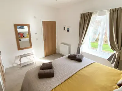 a bedroom with a bed and a large window at Kalipé in Aberfeldy