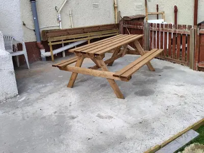 a wooden picnic table sitting next to a fence at Kumba in Kilmarnock