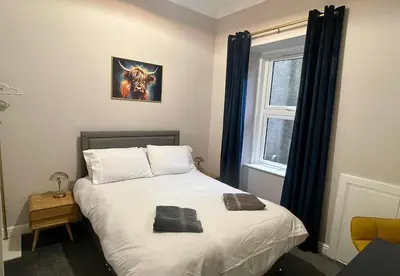 a bedroom with a bed with two towels on it at Beautiful spacious apartment in town centre in Oban