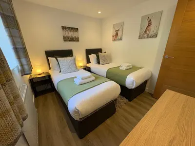 a hotel room with two beds and a door at The Gîte in the Highlands in Acharra