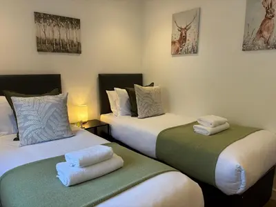 two beds sitting next to each other in a room at The Gîte in the Highlands in Acharra