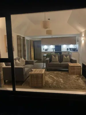 a living room with two couches and a kitchen at The Gîte in the Highlands in Acharra