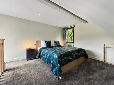a bedroom with a large bed and a window at Aos Sí - Wellness - Jacuzzi - Lodges in Ballachulish