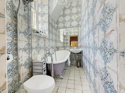 a bathroom with a tub and a toilet and a sink at St John's Old Rectory in Glencoe