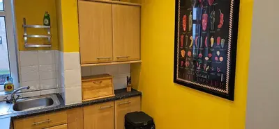 a kitchen with yellow walls and a sink at Snug - Macushla Apartment in Helensburgh