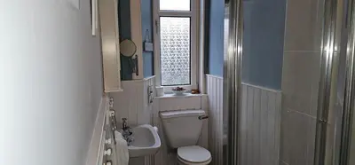 a small bathroom with a toilet and a window at Snug - Macushla Apartment in Helensburgh