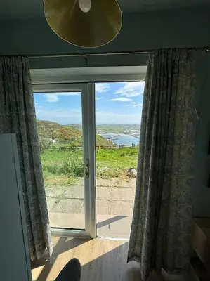 a window in a room with a view of the ocean at Stunning Rathlin cottage in Rathlin Island