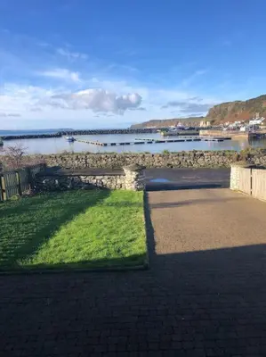 a brick walkway next to a body of water at Beachside House Rathlin Island in Rathlin Island