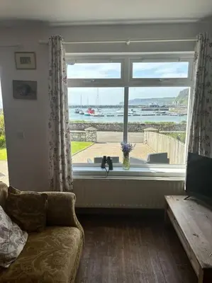 a living room with a window with a view of the ocean at Beachside House Rathlin Island in Rathlin Island