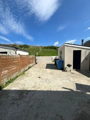 a driveway with a fence and a building at Beachside House Rathlin Island in Rathlin Island