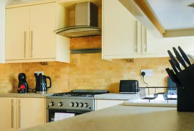 a kitchen with white cabinets and a stove top oven at Register House Family or Contractor 4bed with Garden Driveway in Bellshill