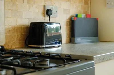 a microwave sitting on top of a counter next to a stove at Register House Family or Contractor 4bed with Garden Driveway in Bellshill