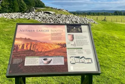 a sign in a field next to a rock wall at Kilin in Lochgilphead
