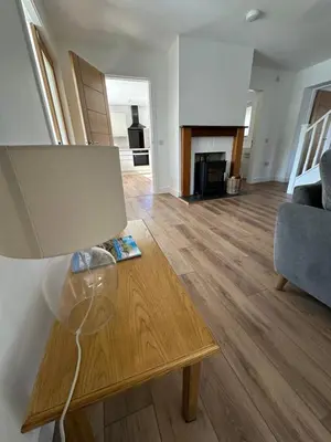 a living room with a table and a fireplace at Highland Hideaway in Fort William