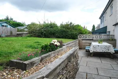 a garden with a table and flowers in a yard at Lang Toon House - 3 bedrooms in Auchterarder