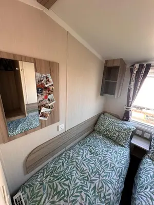 a small room with a bed and a mirror at Swift 3-Bedroom Caravan Located in Uddingston, Glasgow at Maryville Caravan Site in Uddingston