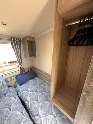 a small bedroom with a bed in a trailer at Swift 3-Bedroom Caravan Located in Uddingston, Glasgow at Maryville Caravan Site in Uddingston