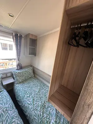 a small room with a bed and a door at Swift 3-Bedroom Caravan Located in Uddingston, Glasgow at Maryville Caravan Site in Uddingston
