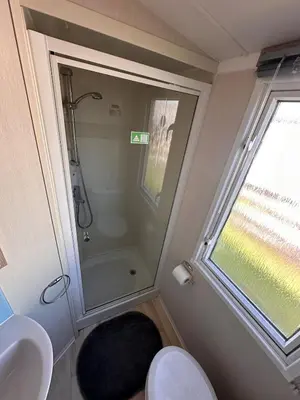 a bathroom with a shower and a toilet and a window at Swift 3-Bedroom Caravan Located in Uddingston, Glasgow at Maryville Caravan Site in Uddingston