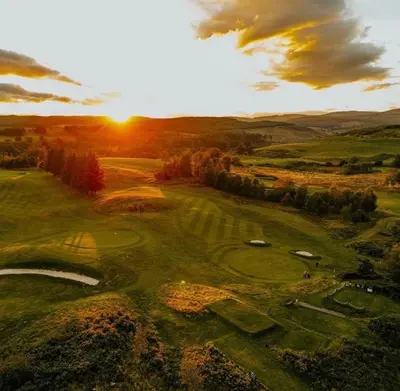an aerial view of a golf course at sunset at Luxury High Street Apartment in Moffat