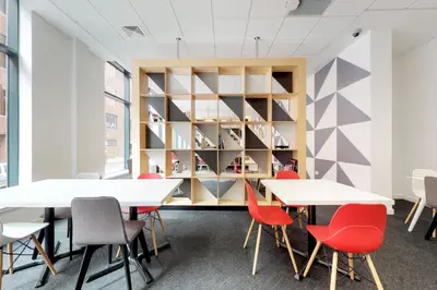 a room with tables and chairs and a book shelf at Abodus St James Glasgow in Glasgow