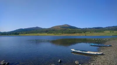 two boats sitting on the shore of a lake at Idyllic Waterside Penthouse in Callander