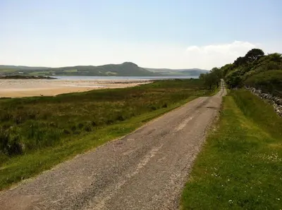 a dirt road next to the beach at Cnocachanach Cottage in Tarbert
