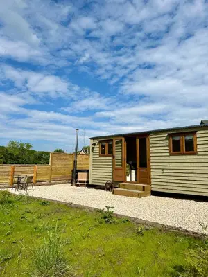 a small caravan sitting on top of a gravel yard at Lintmill Lodges - Thistle Shepherds Hut in Sorn