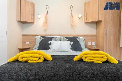 a bed with two yellow towels on top of it at Loch Lomond - Ard Lui Lodge in Ardlui