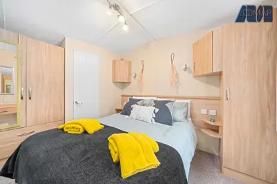 a bedroom with a bed with yellow towels on it at Loch Lomond - Ard Lui Lodge in Ardlui