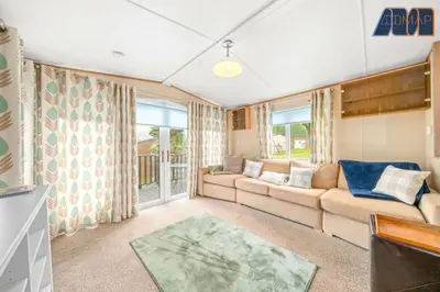 a living room with a couch and a tv at Loch Lomond - Ard Lui Lodge in Ardlui