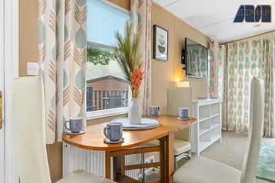 a table and chairs in a tiny house at Loch Lomond - Ard Lui Lodge in Ardlui