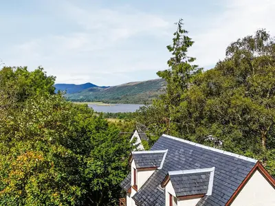 a house with a view of a lake and mountains at Pine Marten Cottage in Ballachulish