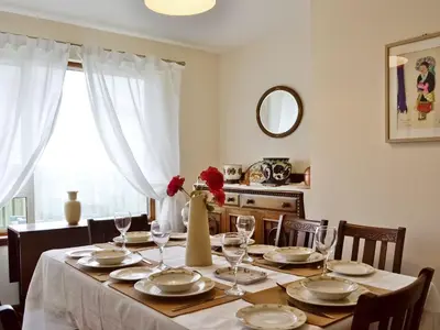 a dining room table with a vase of flowers on it at Crubisdale in Blairmore