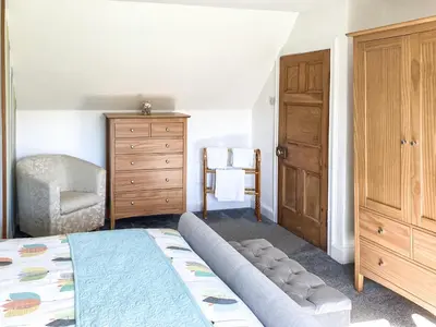 a bedroom with a bed and a dresser at Balnowlart Lodge in Ballantrae