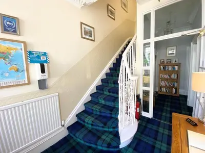 a staircase in a home with a blue carpet at Daviot Guest House in Ayr