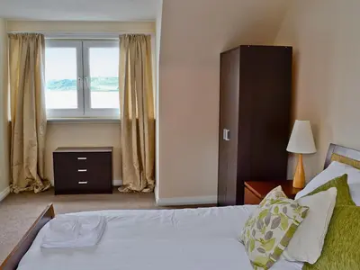 a bedroom with a bed and a large window at Seaview in Oban