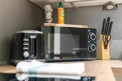 a microwave sitting on top of a counter at Upper Grove 2 Bedroom Apartment - Edinburgh in Edinburgh
