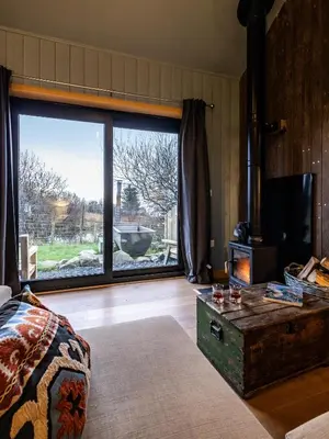 a living room with a large window and a bed at Jura - The Rusty Hut in Craighouse