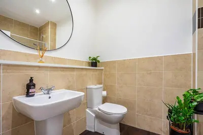 a bathroom with a sink and a toilet and a mirror at Bright, modern 2 bedroom house with free parking! in Edinburgh