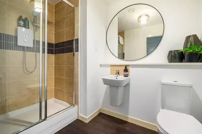 a bathroom with a shower and a toilet and a sink at Bright, modern 2 bedroom house with free parking! in Edinburgh
