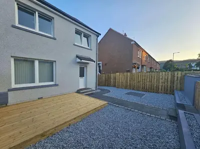 a backyard with a wooden deck in front of a house at Ardenslate House in Kirn