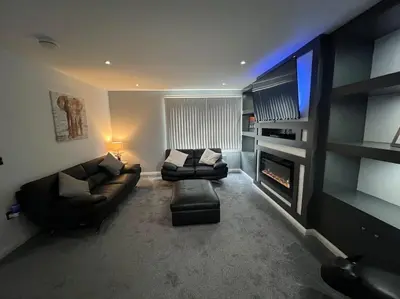a living room with two couches and a flat screen tv at Ardenslate House in Kirn