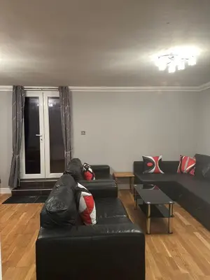 a living room with a black couch and a table at Edinburgh Lauriston 4 bedroom 7 beds duplex in Edinburgh